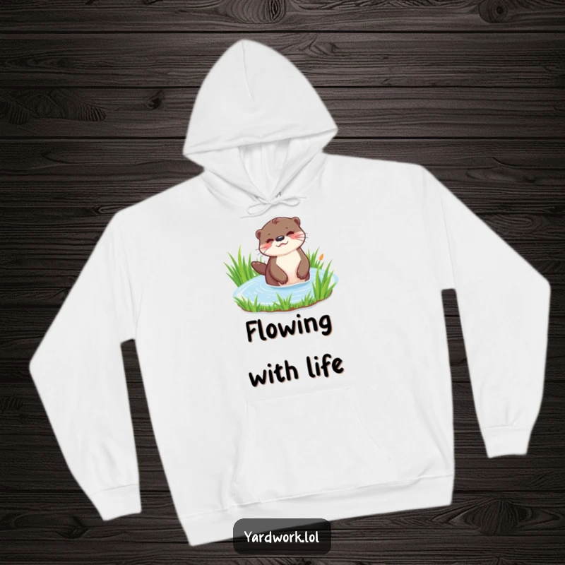 Funny hoodie depicting a playful otter happily watering a patch of vibrant green grass. Cozy and full of whimsy.